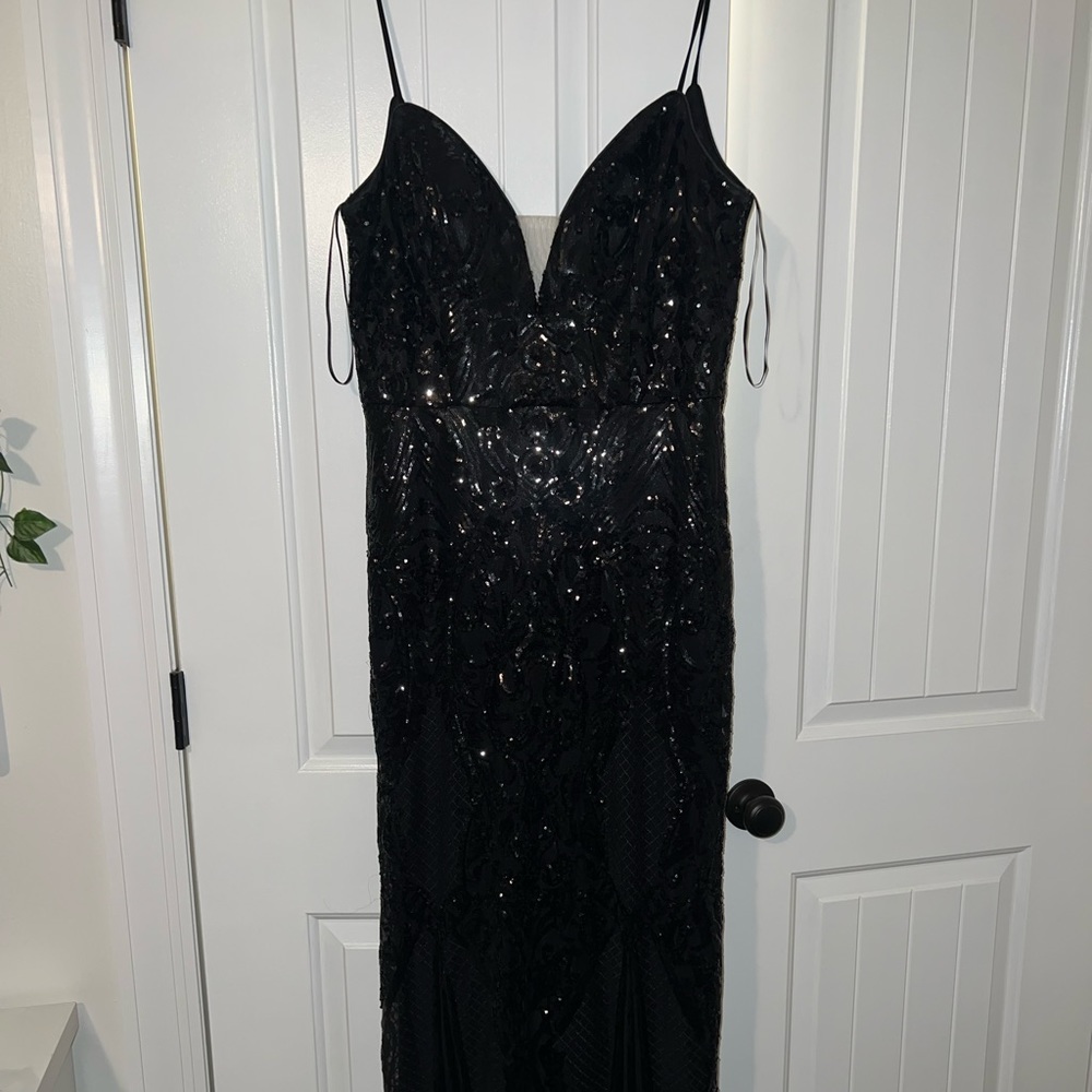 Black sequined with a plunge neckline and swoop back Amelia Couture prom dress!
